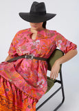 front view of Marina Rinaldi Stecca Cotton Print Tiered Long Dress styled with belt and sun hat on plus model in Fuchsia Print