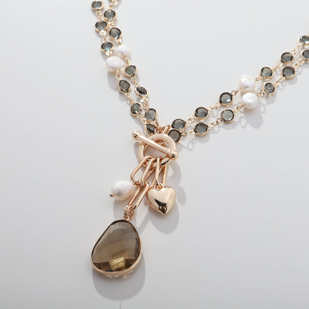 Gold-tone bead necklace with faux pearl accents and teardrop brown pendant