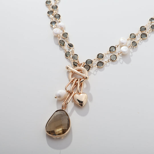 Gold-tone bead necklace with faux pearl accents and teardrop brown pendant