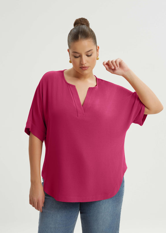 front view of Mat plus size txtured polyester air-wash Split Neck Curved Hem Top in Fuchsia