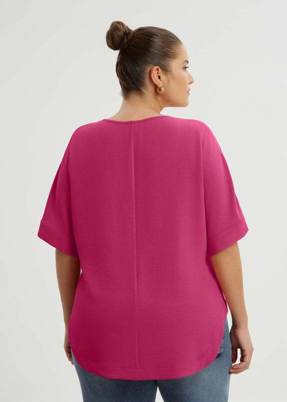back view of Mat plus size txtured polyester air-wash Split Neck Curved Hem Top in Fuchsia
