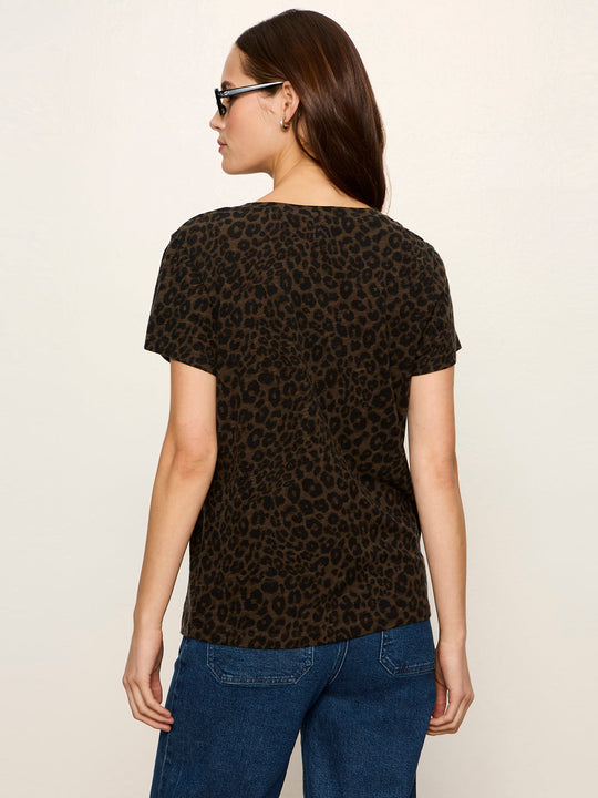 Back view of short-sleeve leopard print tee in dark olive and black, worn with blue jeans