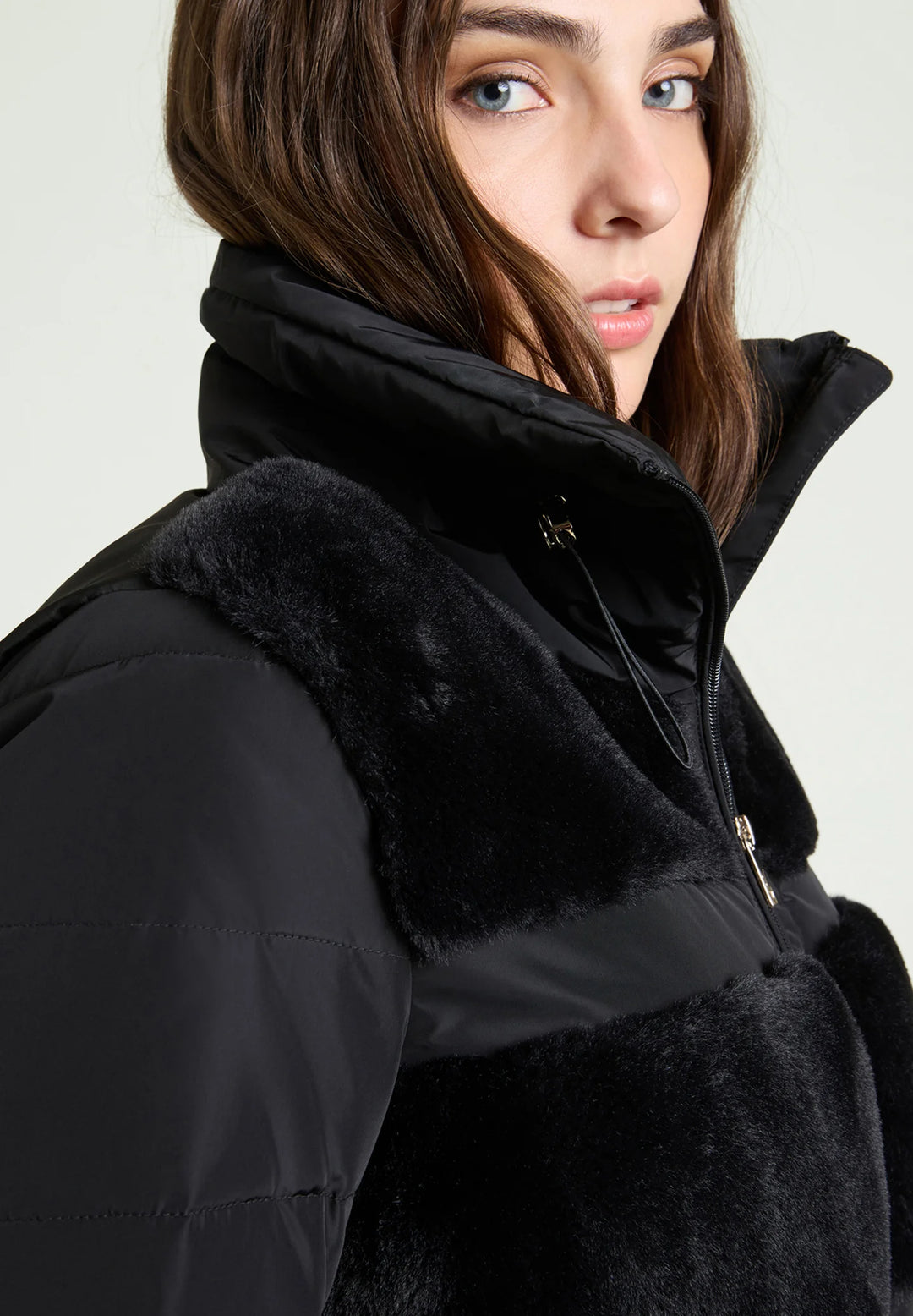 Black puffer jacket detail: plush shoulder panel and zippered front