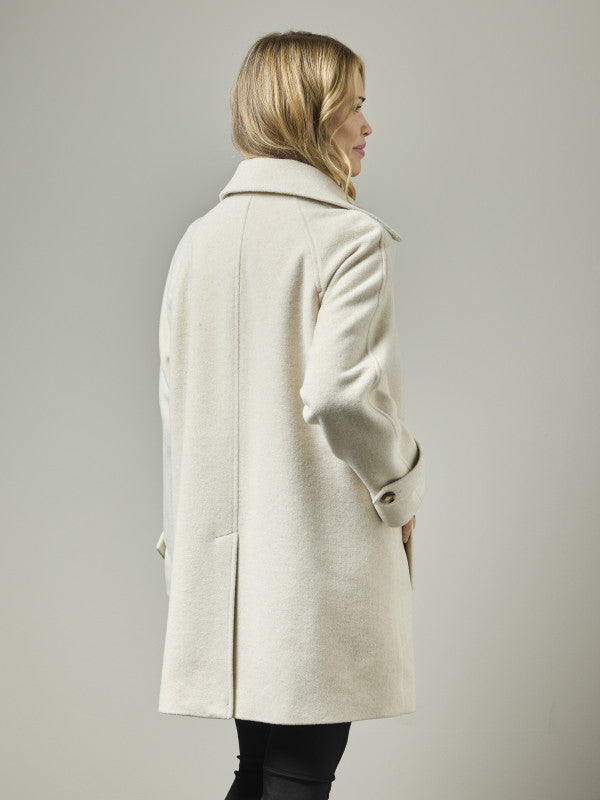 Wool blend coat in cream, back view on model, showing raglan shoulders and structured silhouette