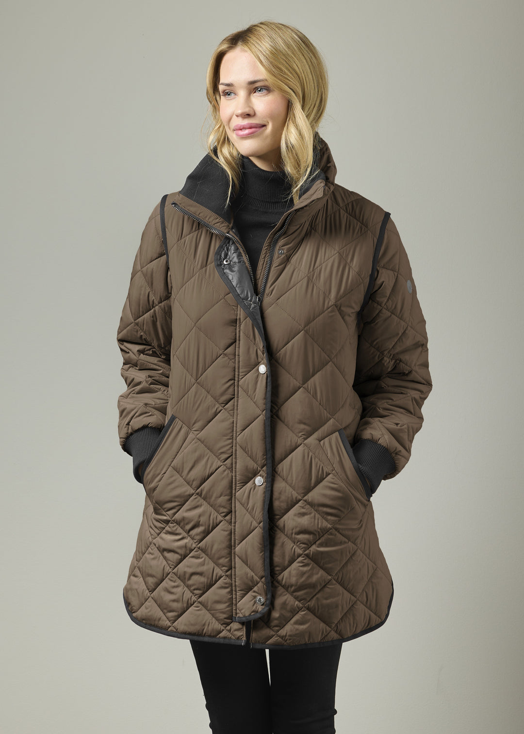 Mocha quilted knee-length coat with knit collar, front zip, and black storm cuffs