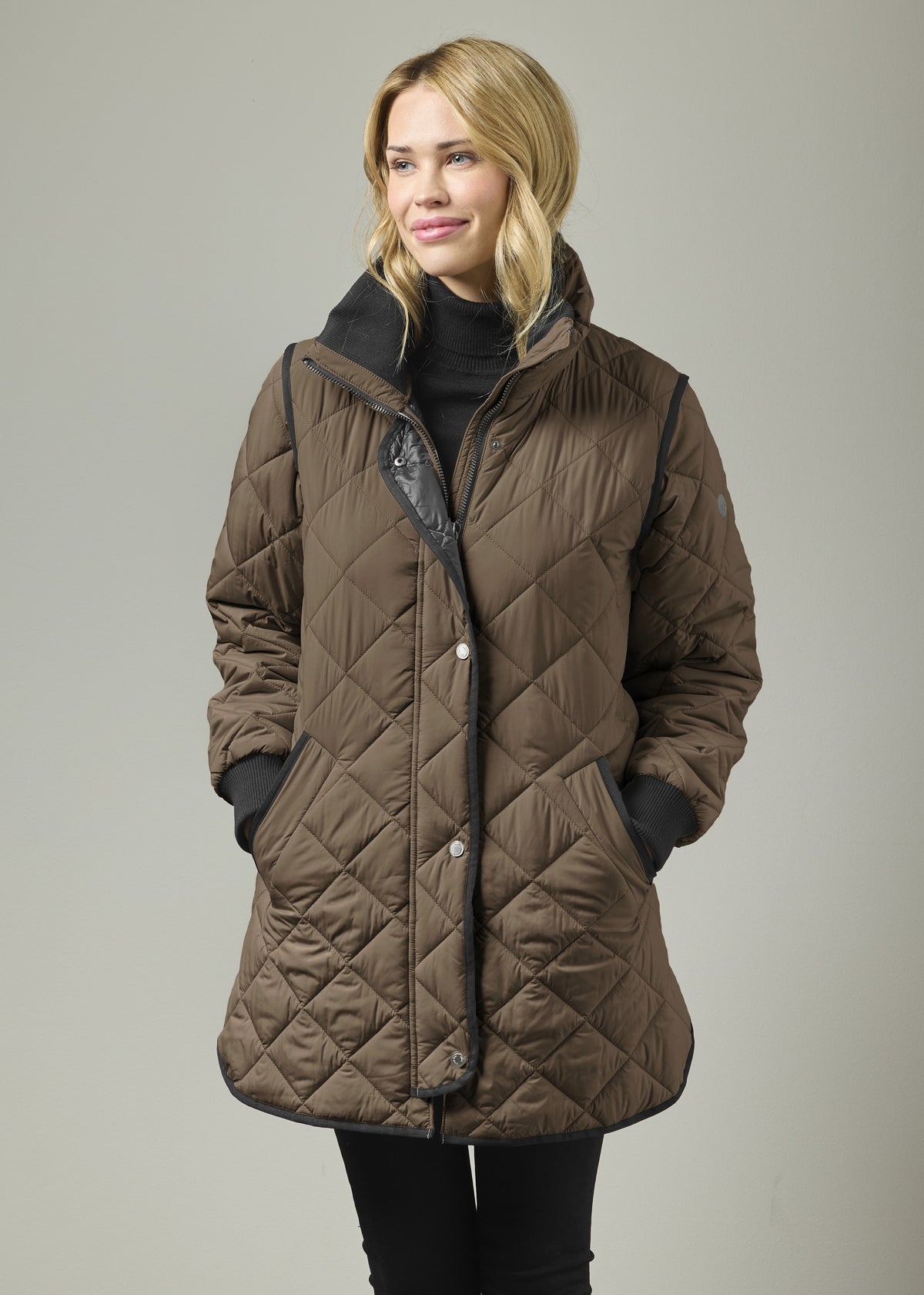 Mocha quilted knee-length coat with knit collar, front zip, and black storm cuffs
