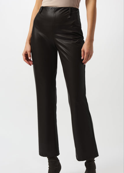 Person wearing black leather pants on a white background