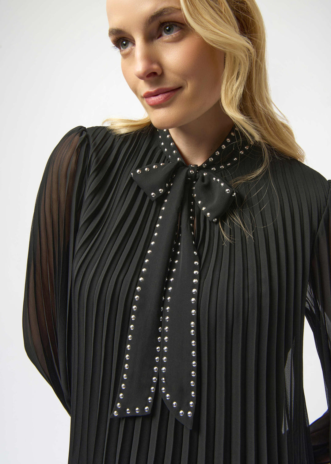 close up front view of plus size Joseph Ribkoff Pleated Chiffon A-line dress with Tie Neck in Black