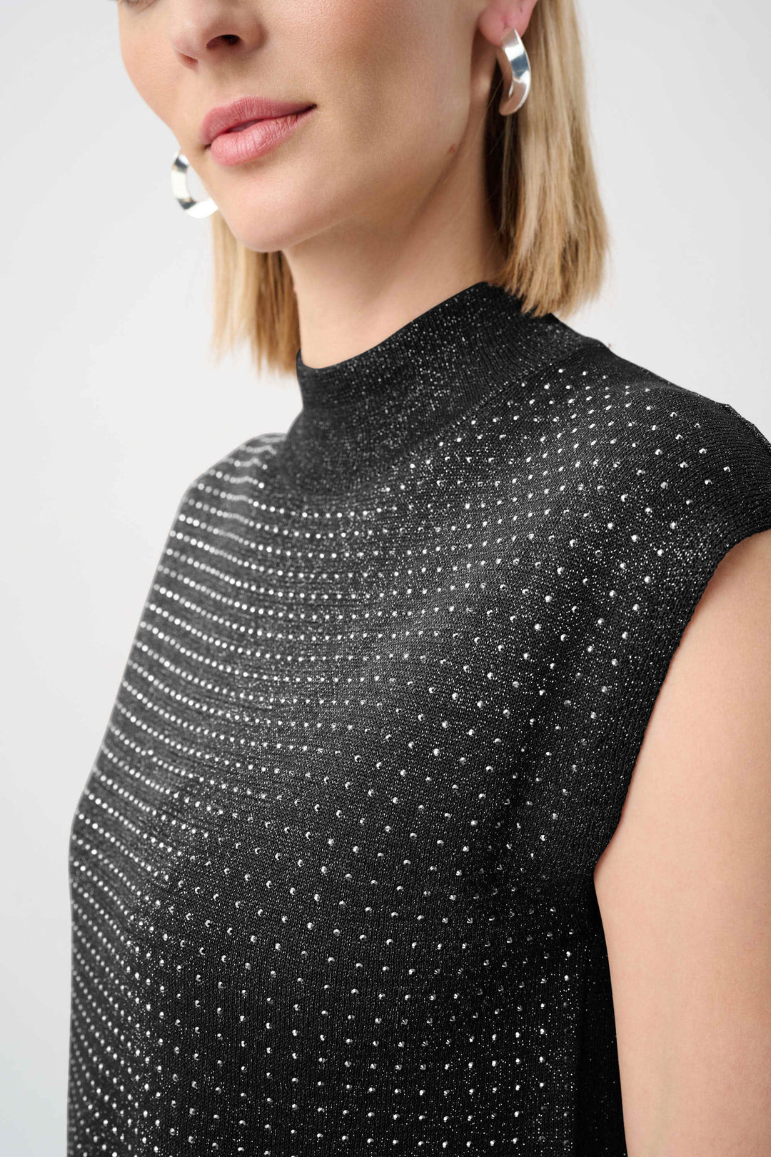 Black mock-neck sleeveless sweater close-up of dotted iron-on texture
