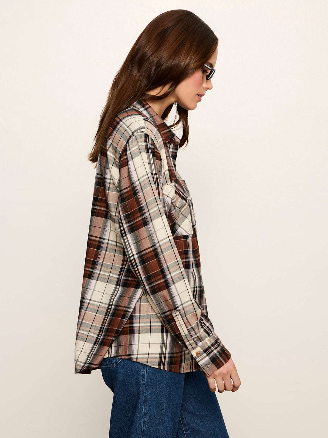 Side view of long-sleeve plaid button-up shirt with chest pocket, worn with jeans