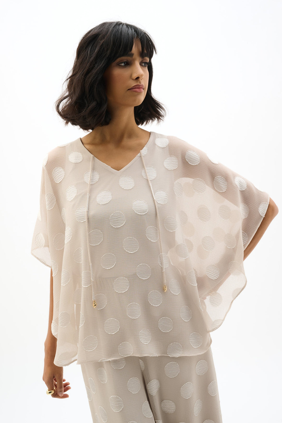 Flowy chiffon poncho top with white polka dot pattern and matching wide-leg pants