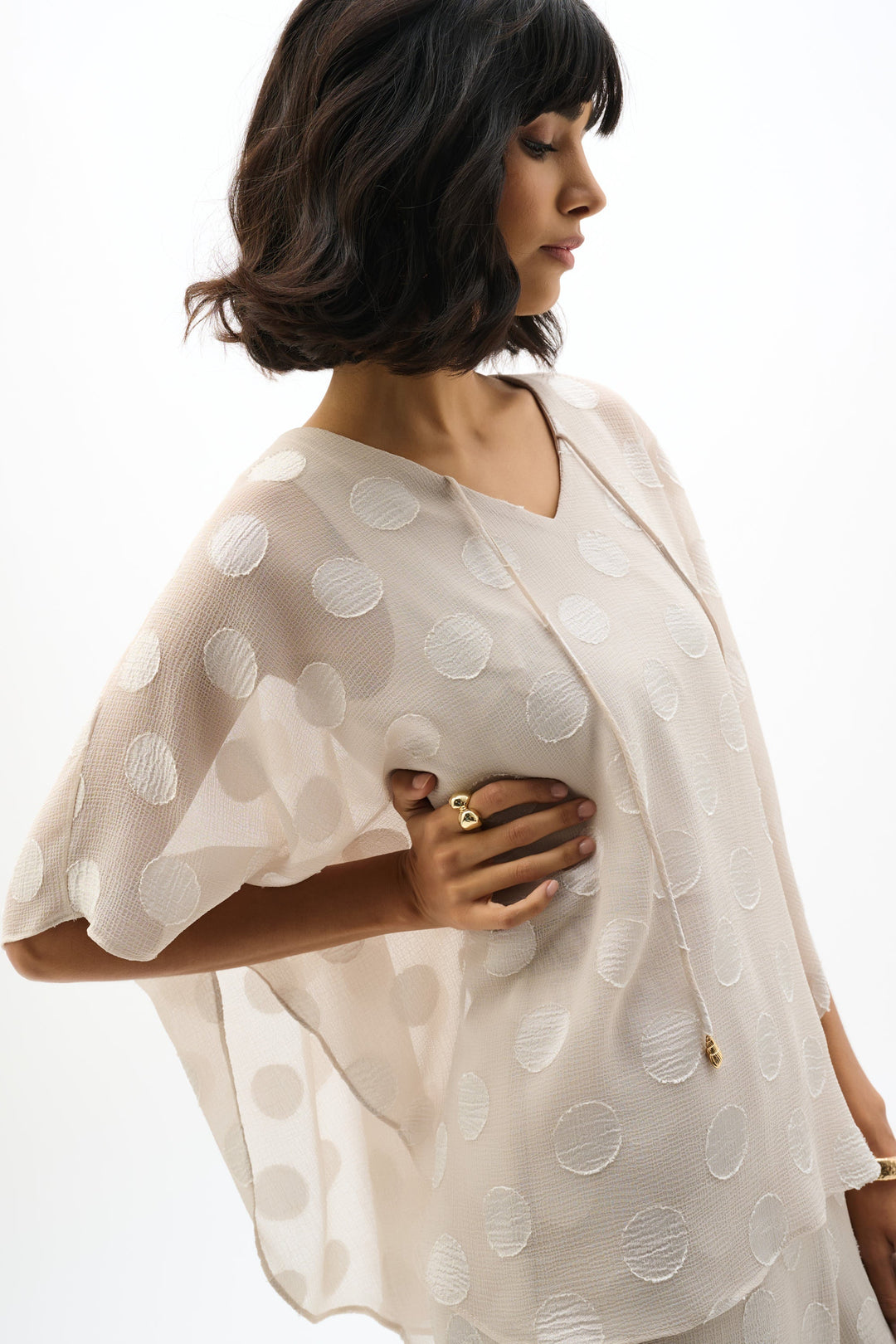 Light colored chiffon poncho top with polka dot pattern, three-quarter sleeves, side view