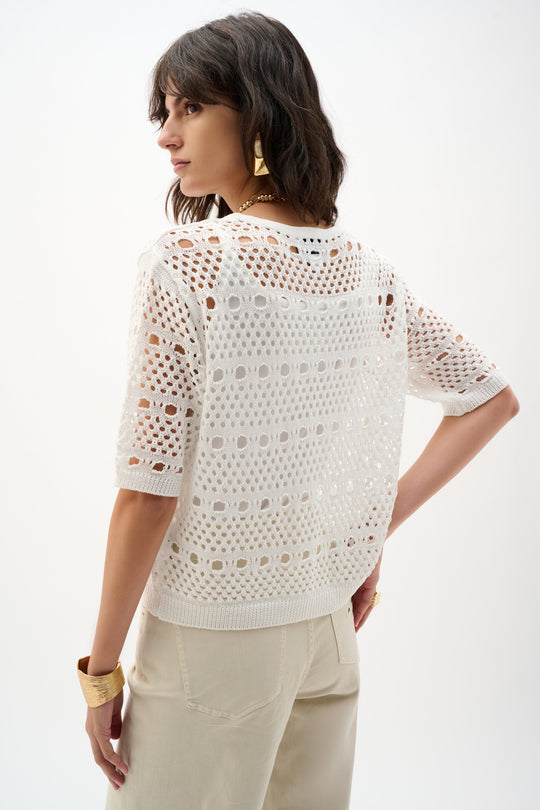 White open-knit sweater with cutout pattern worn by model, back view showing textured stitch detail
