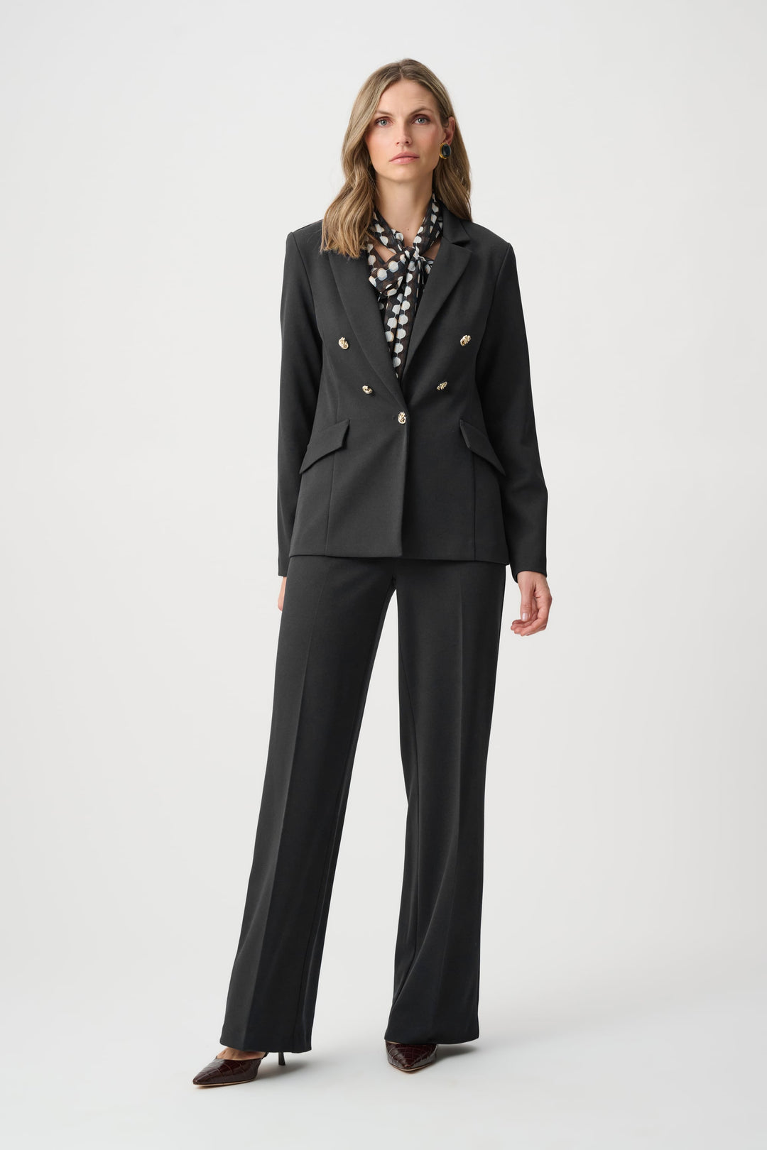 Black tailored blazer with brass buttons and flap pockets, long sleeves.