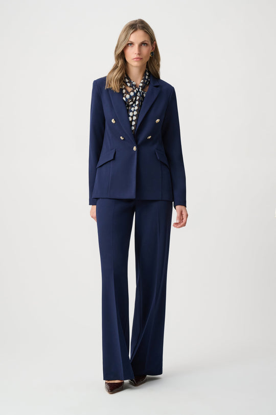 Indigo fitted blazer with brass buttons and flap pockets, worn with matching pants