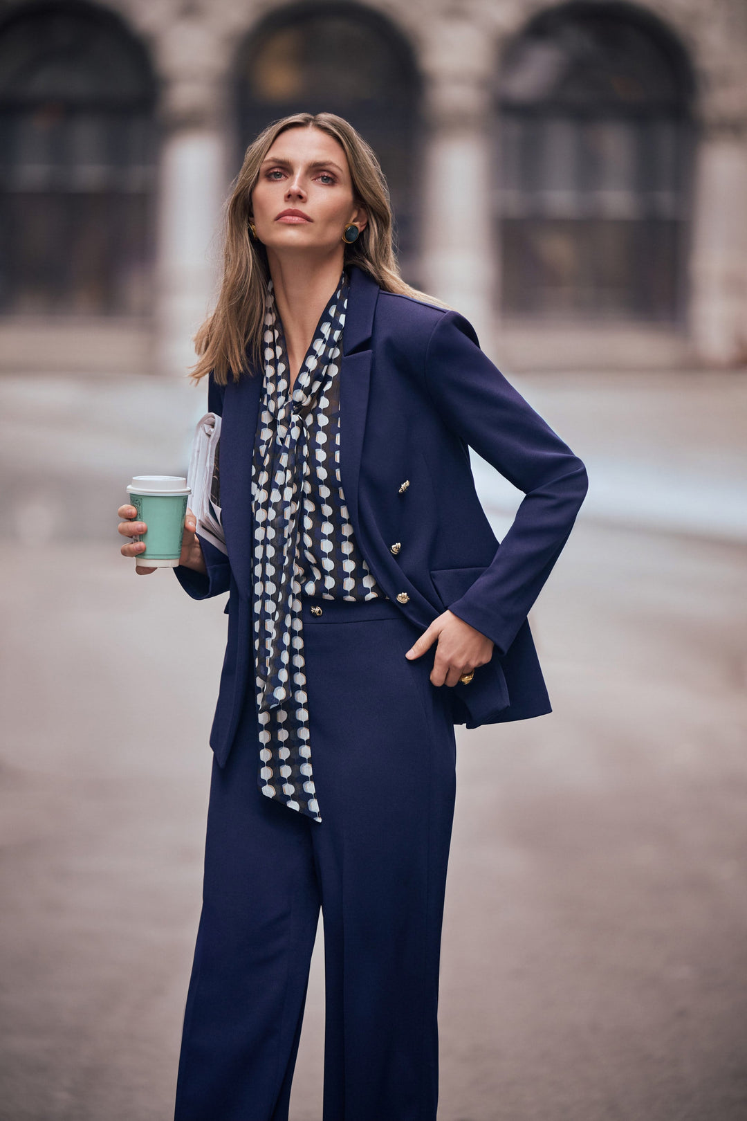 Indigo fitted blazer with brass buttons and flap pockets, styled with patterned scarf