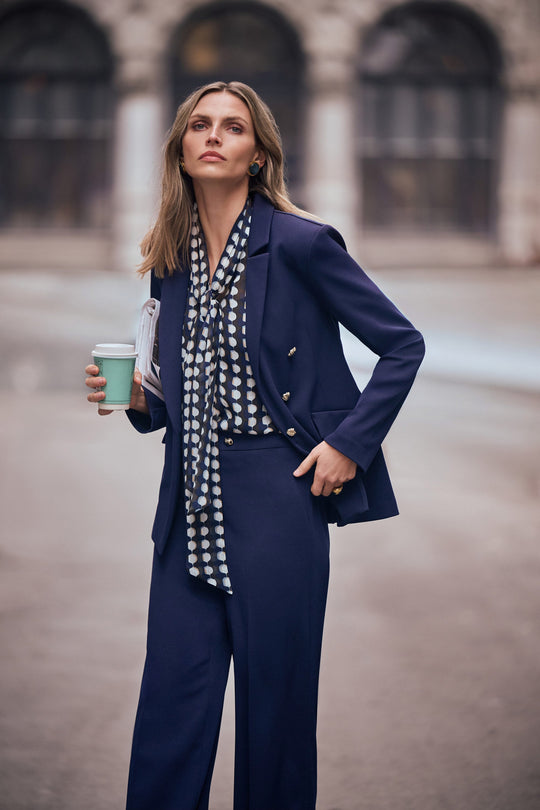 Indigo fitted blazer with brass buttons and flap pockets, styled with patterned scarf