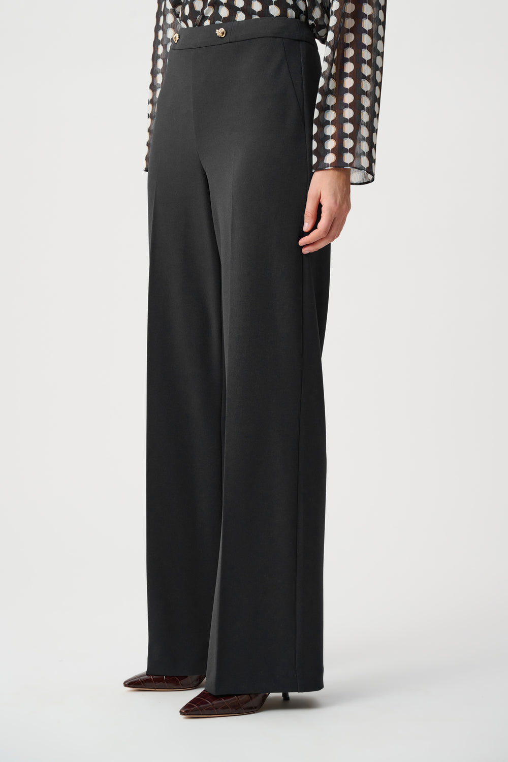 Black wide-leg crepe pants with ankle-length wide hems and gold waistband buttons