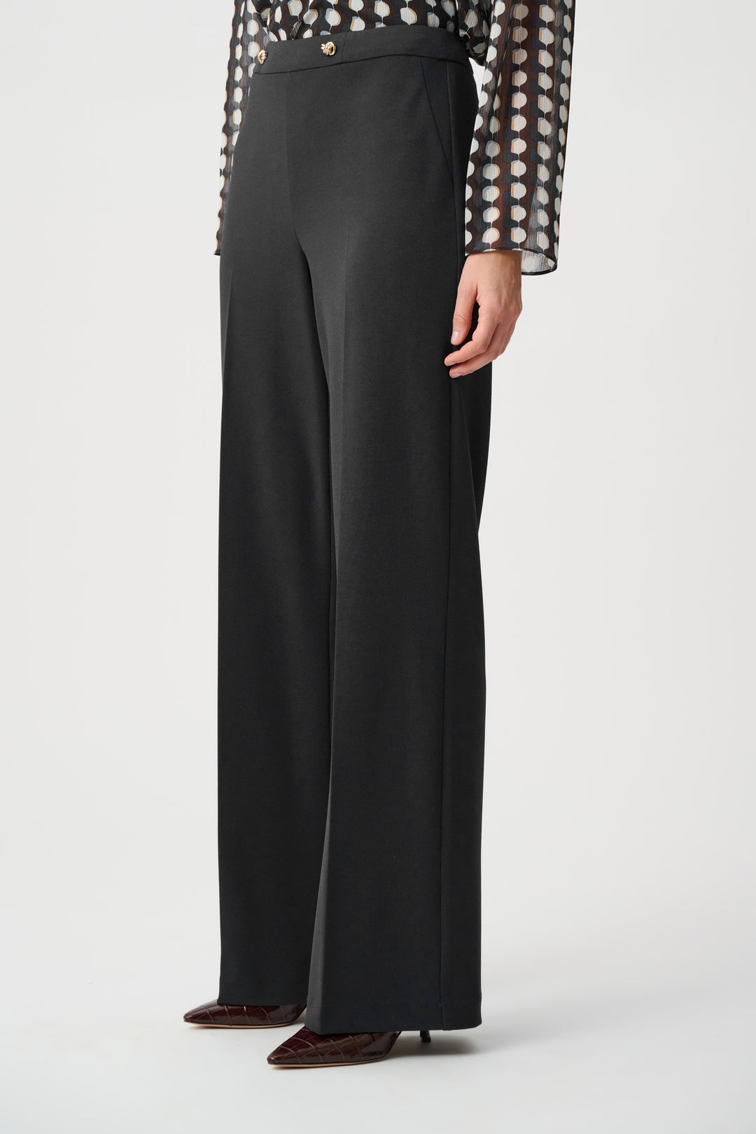 Black wide-leg crepe pants with ankle-length wide hems and gold waistband buttons