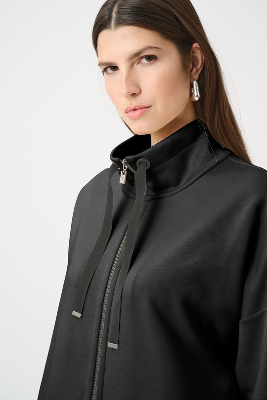 Black funnel-neck zip jacket with drawstring detail and textured fabric