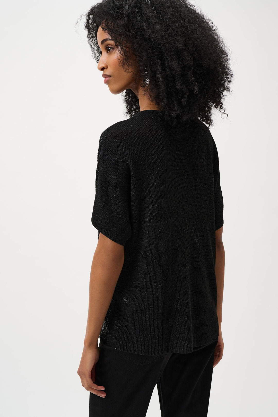Black metallic knit short-sleeve top with relaxed fit, shown from side angle
