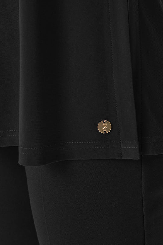 Black tunic hem detail with decorative gold snap, straight cut