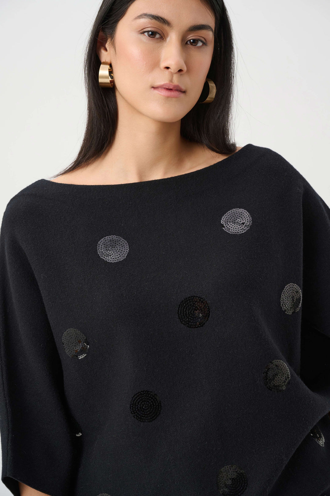 Black sweater close-up with metallic sequin dot embroidery texture