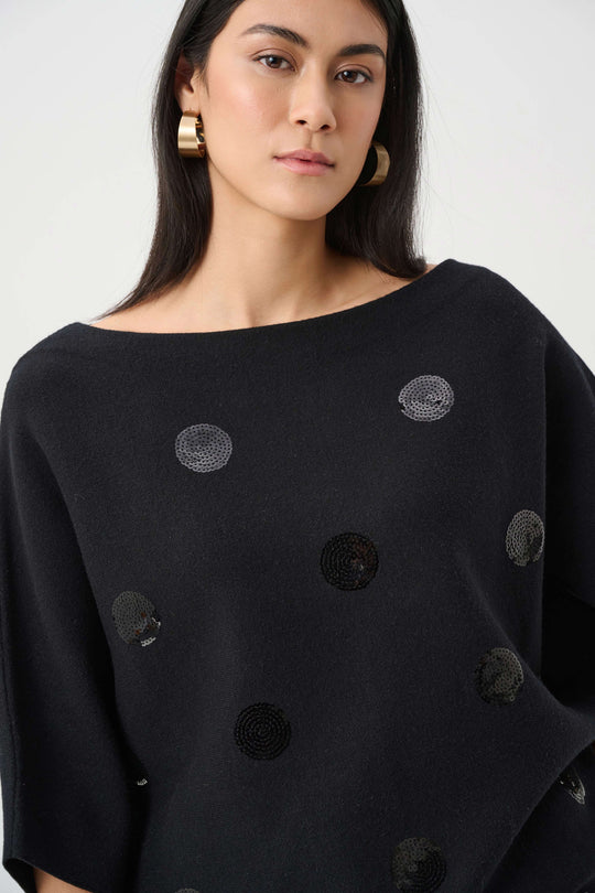 Black sweater close-up with metallic sequin dot embroidery texture