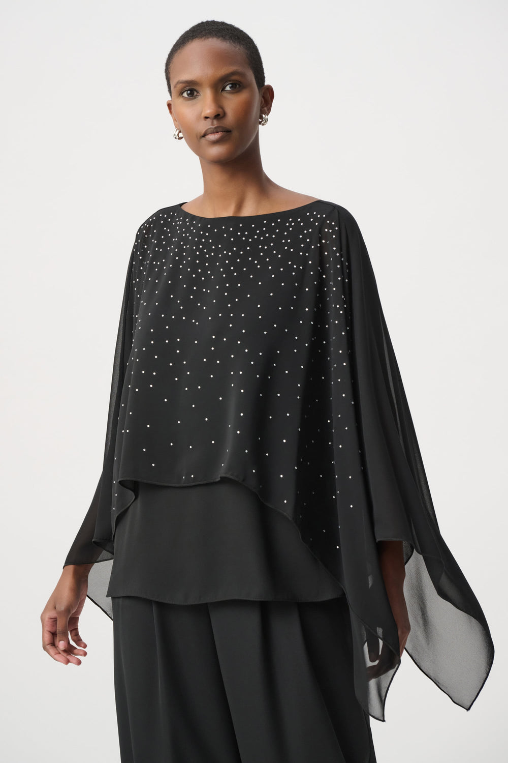 Rhinestone-embellished black poncho with draped sleeves and layered hem