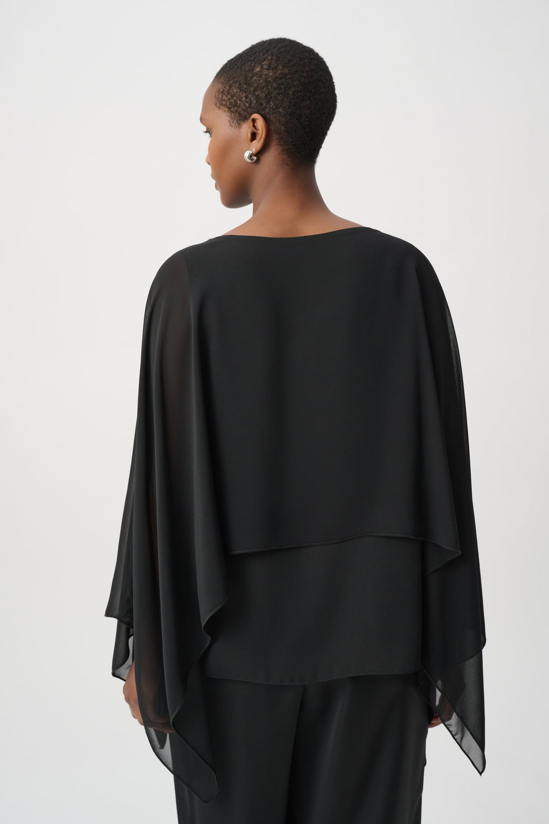 Black rhinestone poncho back view with flowing cape sleeves and layered hem