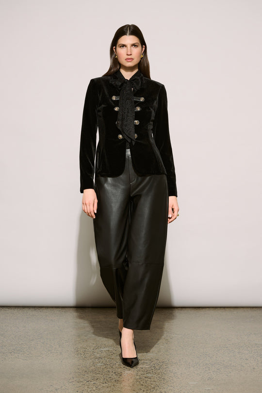 Model wearing black leatherette barrel leg pants with velvet military blazer