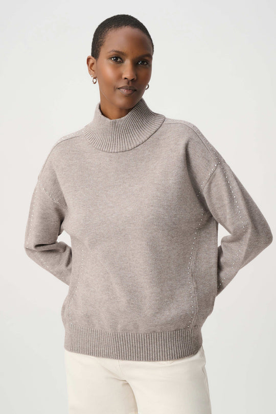 Taupe turtleneck knit sweater with embellished button-like studs on shoulder seam