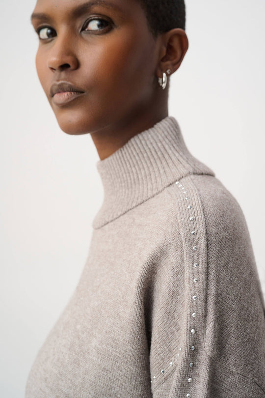 Taupe turtleneck sweater with stud embellishments along shoulder and upper sleeve