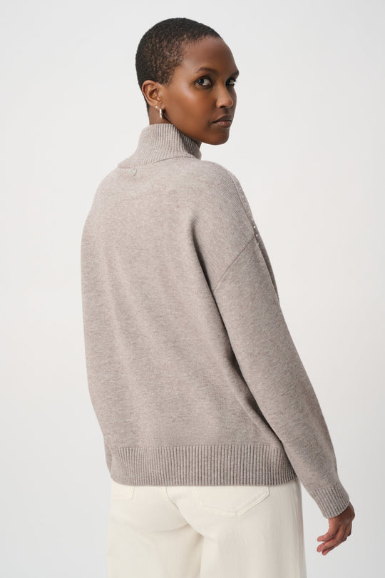 Taupe turtleneck sweater with ribbed hem and stud embellishment on back shoulder