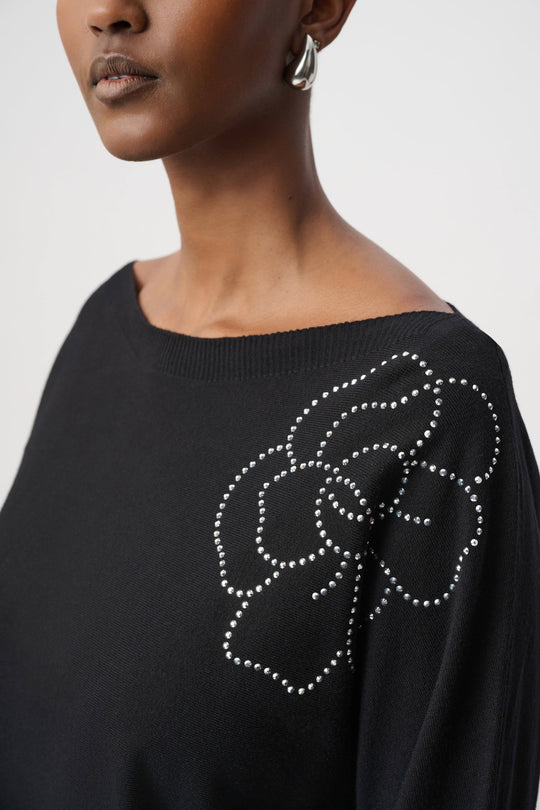 Black pullover with large rhinestone bow-style flower applique at neckline