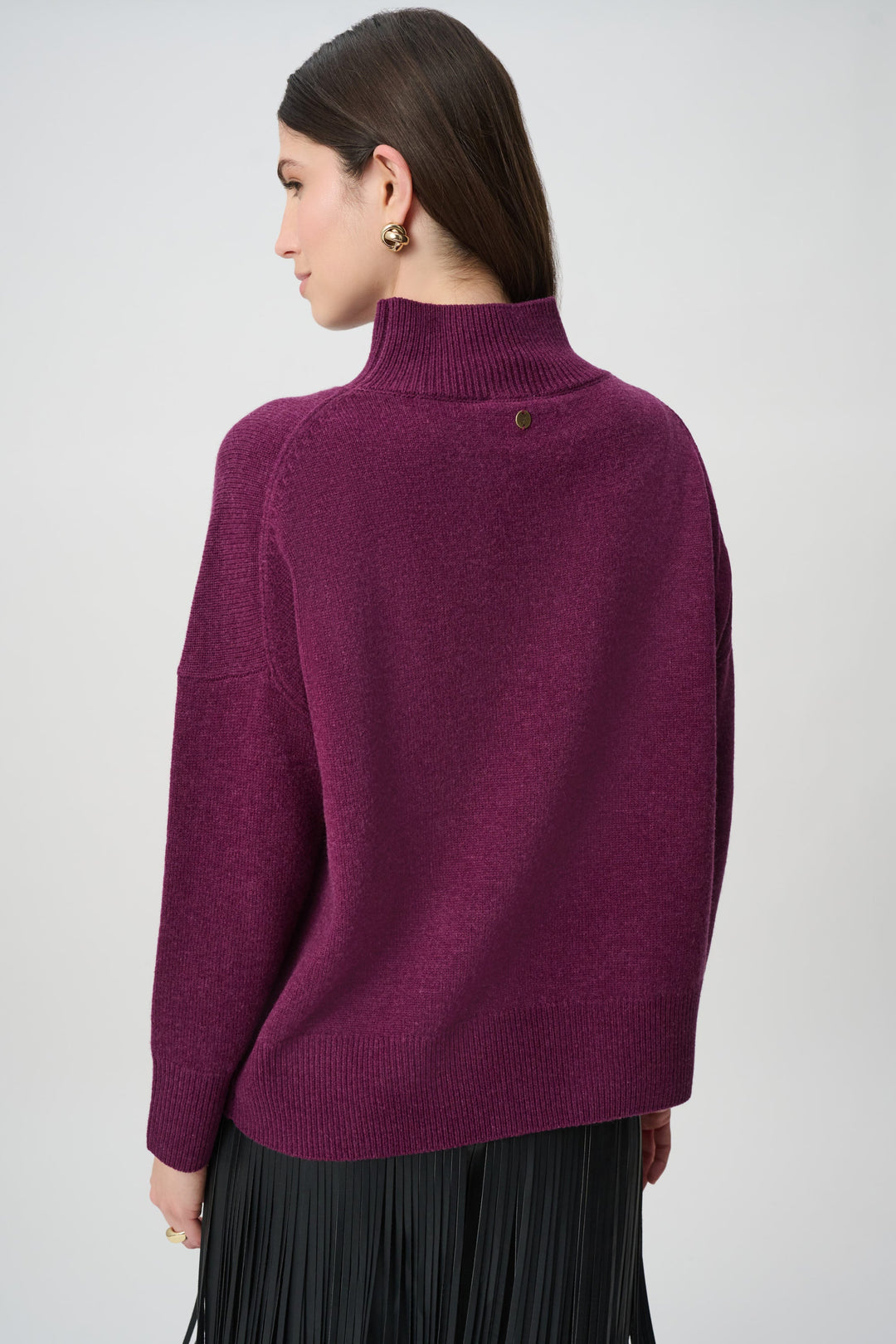 Back view of Joseph Ribkoff wool mock neck sweater in deep elderberry purple with black pleated skirt