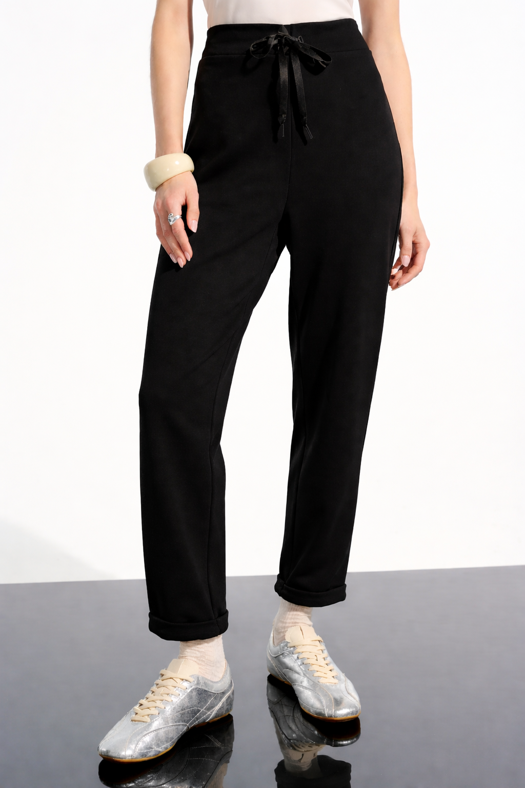 Black jogger pants with drawstring waist and rolled cuffs on model