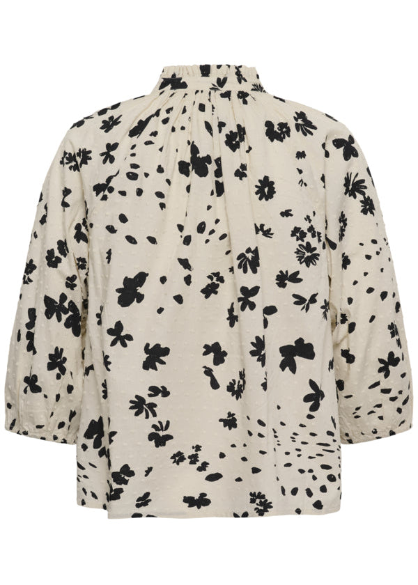 Beige blouse with black floral pattern on a white background