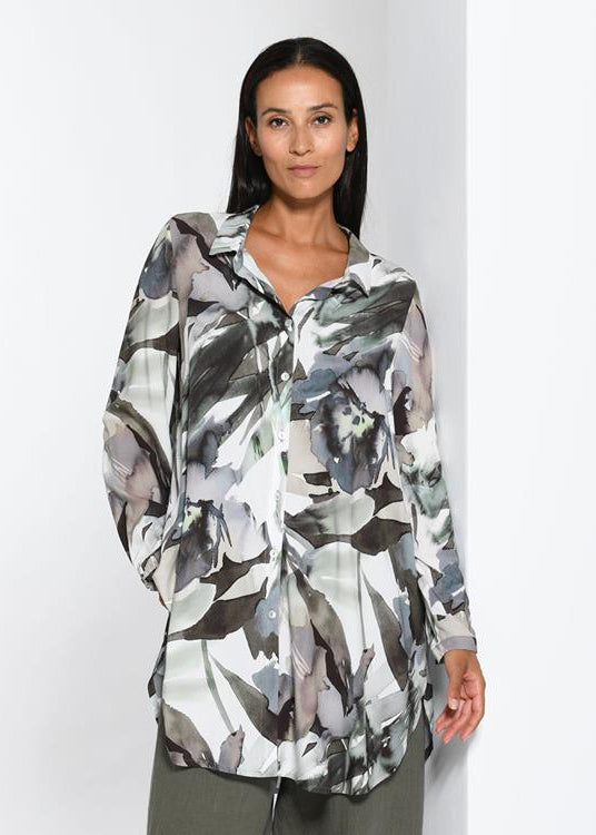 Woman wearing a floral patterned shirt against a white background