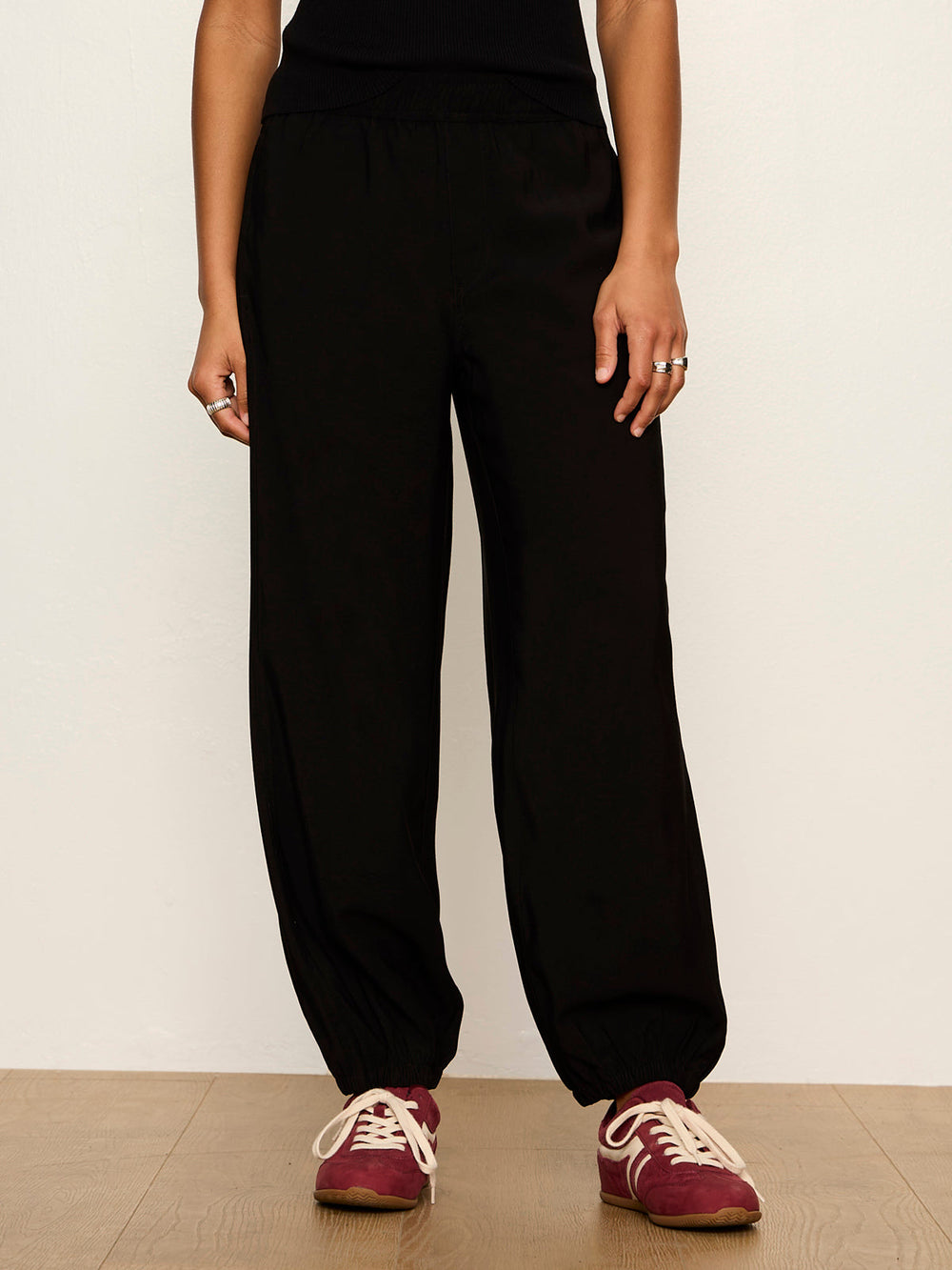Black balloon jogger pants with elastic waistband and cuffed ankles, front view on model
