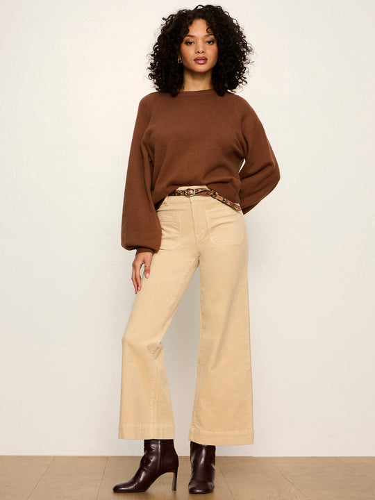 Cocoa brown crewneck long-sleeve knit sweater with ribbed cuffs, styled with cream pants