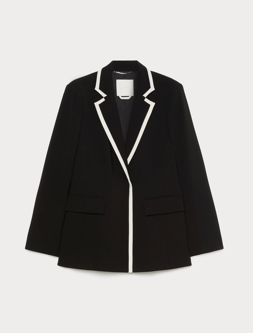Black blazer laid flat on hanger with white contrast lapels and center trim