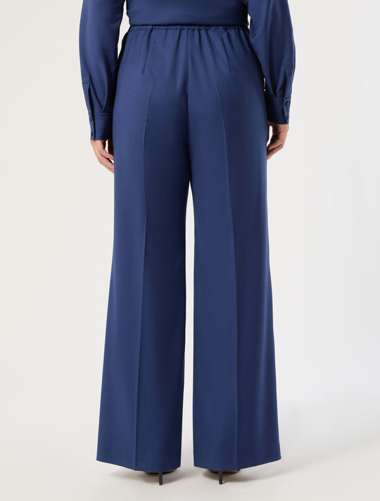 Wide-leg wool trousers with elastic waist and center back seam, rear view on model