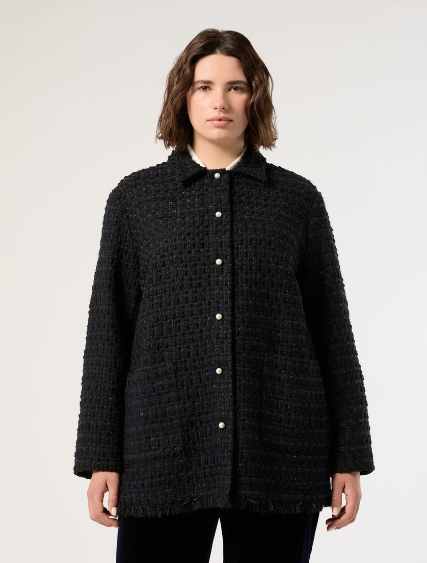 Oversized dark tweed jacket with pearl buttons, fringed hem, and patch pockets, front view on model