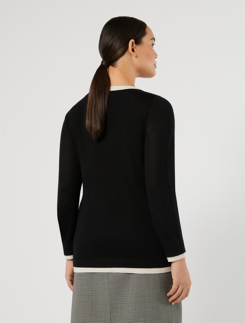 Black long-sleeve crew neck pullover with white contrast trim at collar, cuffs, and hem, back view on model