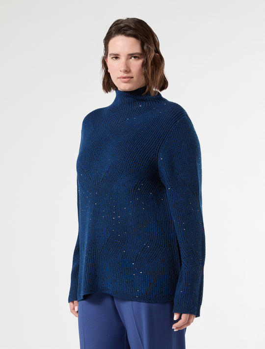 Ribbed knit mock neck sweater with scattered metallic studs in deep blue, three-quarter view on model