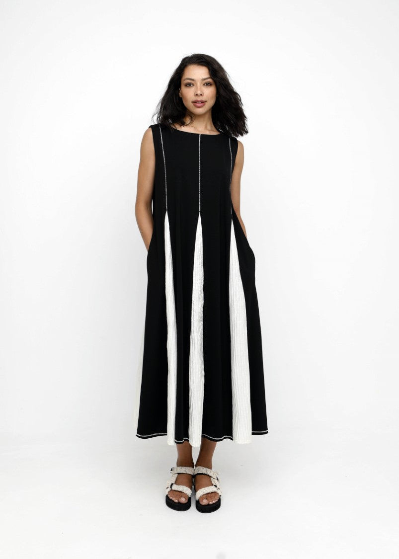 Woman wearing a black sleeveless dress with a white stripe on a white background