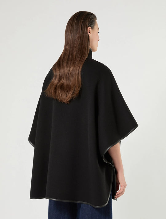 Black cape with stand collar and loose drape, snap-button front; rear view.