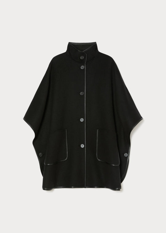 Black poncho-style cape with stand collar, snap buttons, and patch pockets; front view.