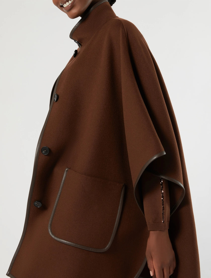 Biscuit faux leather topped cape with stand collar, button front, side pocket trim